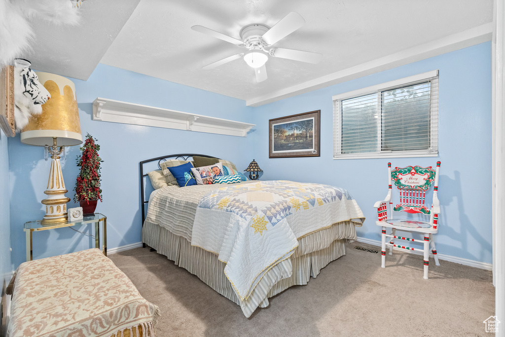 Carpeted bedroom featuring baseboards and ceiling fan