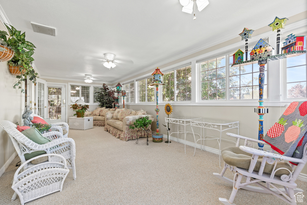 Sunroom / solarium featuring carpet and crown molding