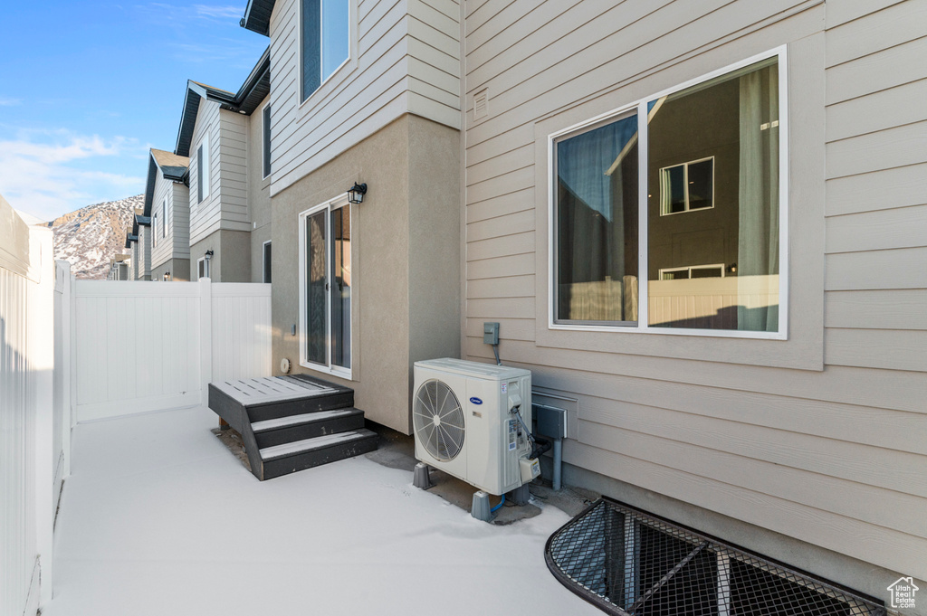 View of patio / terrace with ac unit, fence, and a mountain view