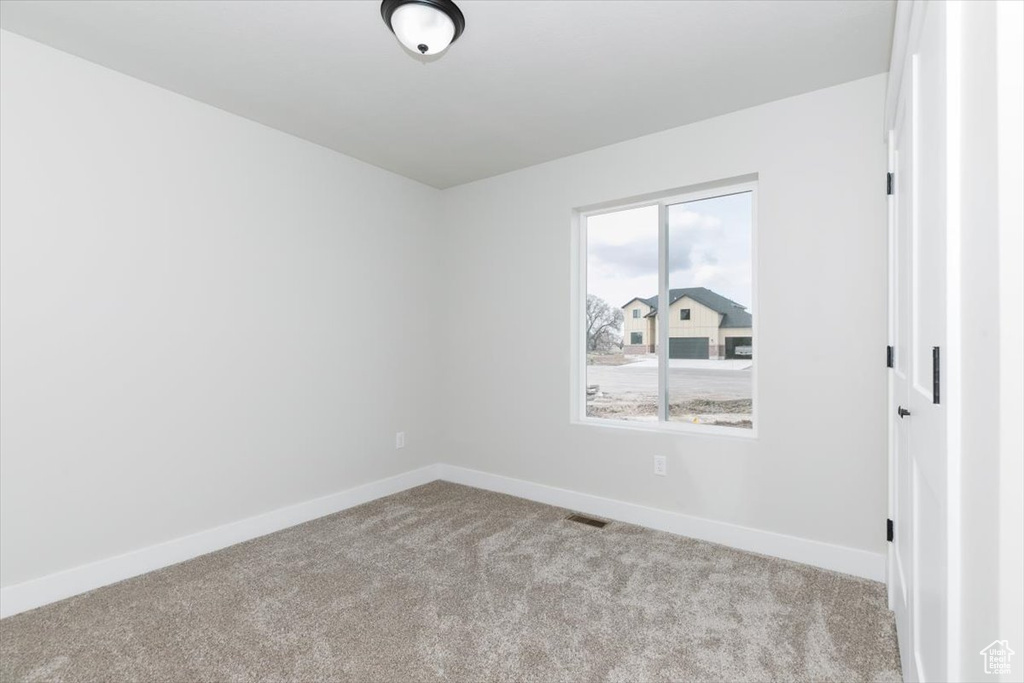 Carpeted spare room with baseboards and visible vents