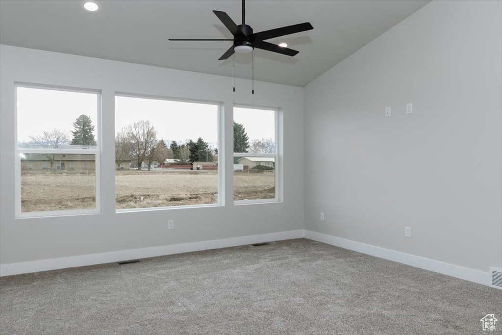 Carpeted empty room with baseboards, visible vents, recessed lighting, and a ceiling fan