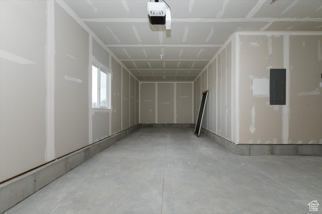 Garage featuring electric panel and a garage door opener