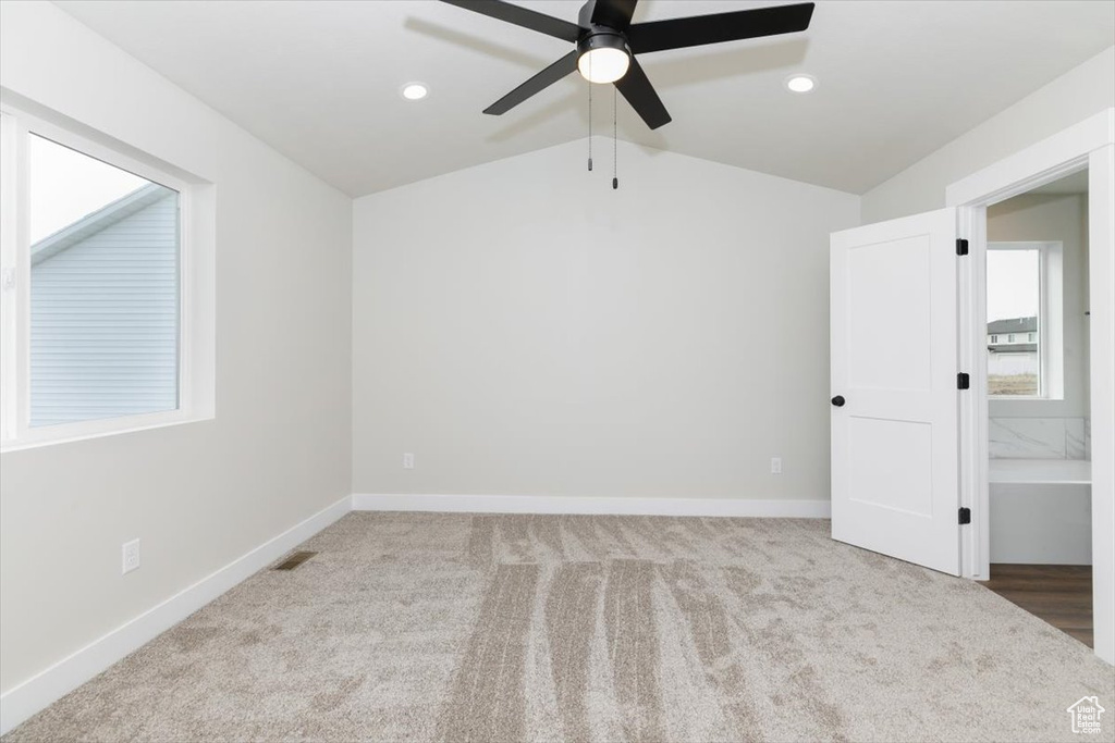 Carpeted empty room with visible vents, baseboards, recessed lighting, a ceiling fan, and lofted ceiling