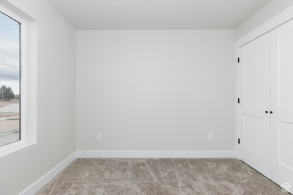Unfurnished bedroom featuring carpet, a closet, and baseboards