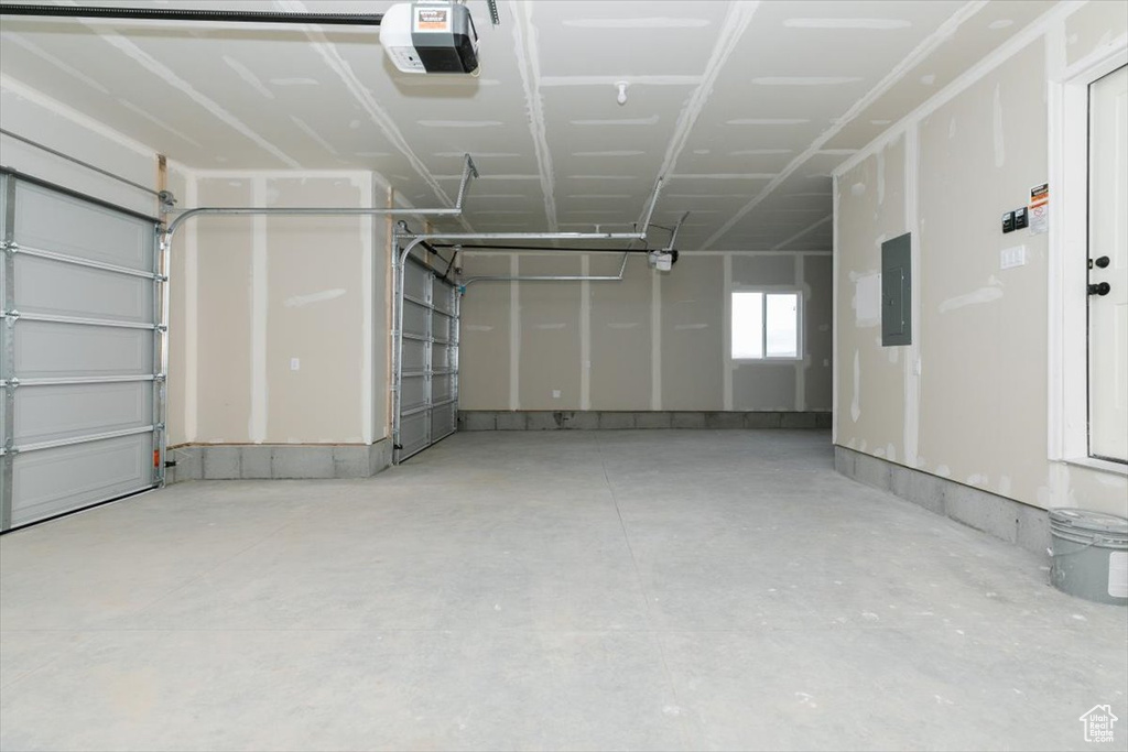 Garage featuring electric panel and a garage door opener