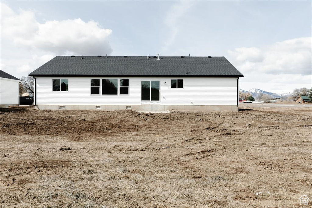 Rear view of house with crawl space and a shingled roof