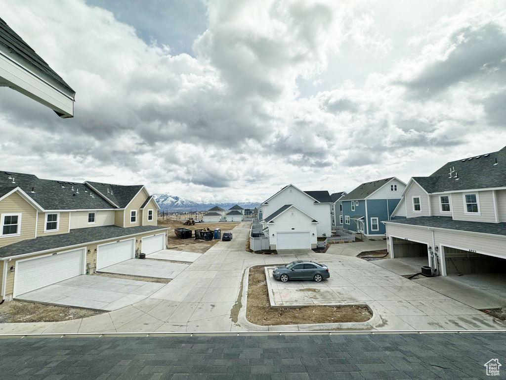 Exterior space with a residential view, driveway, and a garage