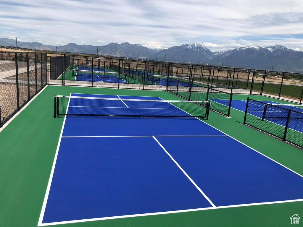 View of tennis court featuring a mountain view, fence, and community basketball court