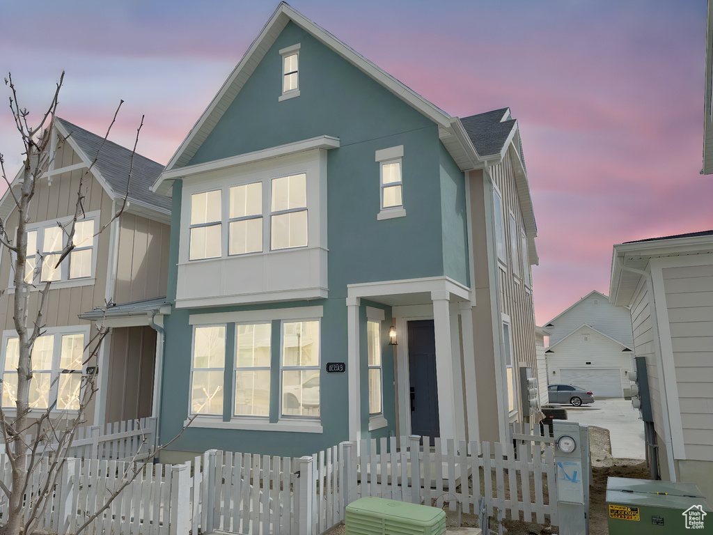 View of front of home featuring a fenced front yard, an outdoor structure, and stucco siding