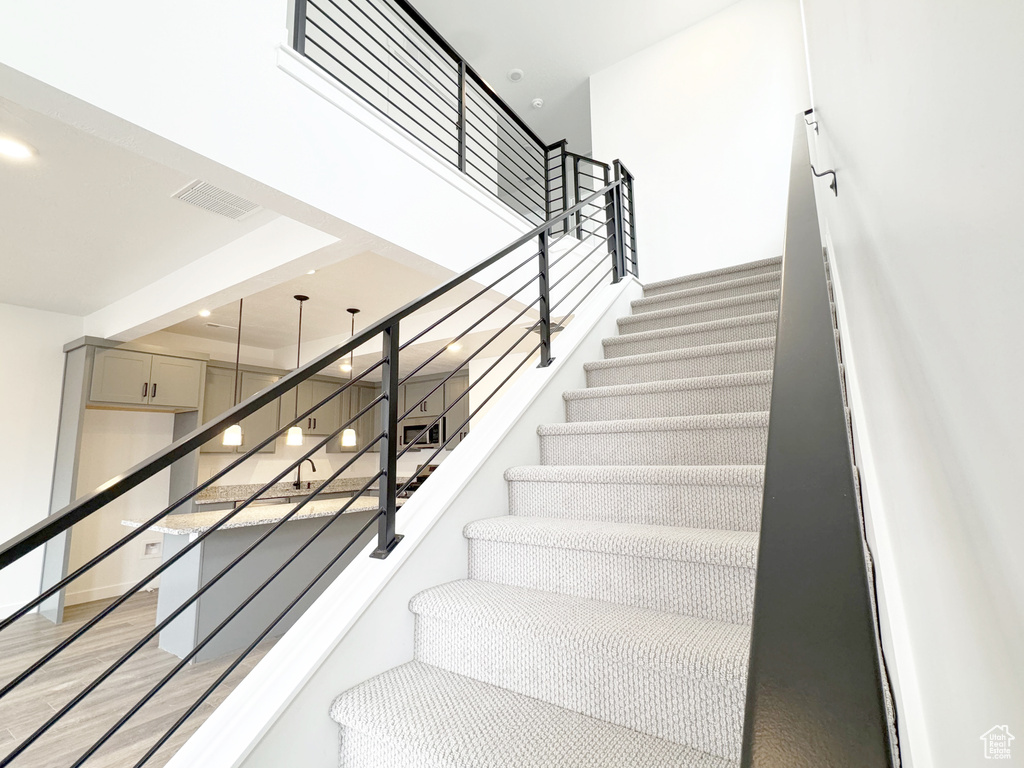 Stairs featuring visible vents and wood finished floors