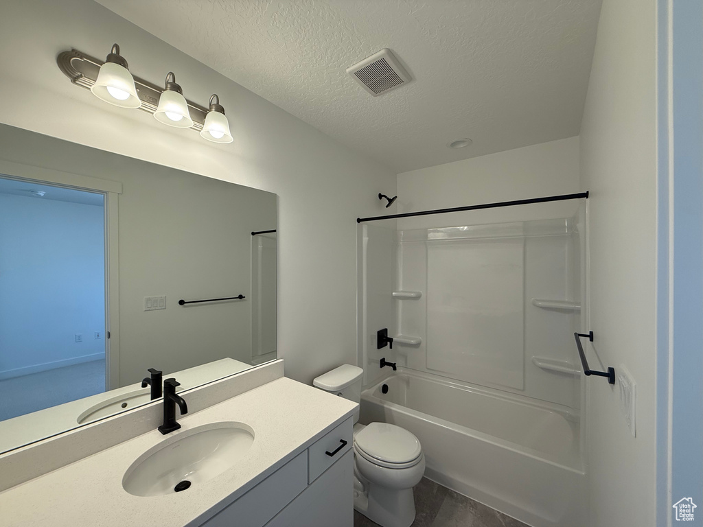Bathroom with vanity, shower / bath combination, a textured ceiling, toilet, and visible vents