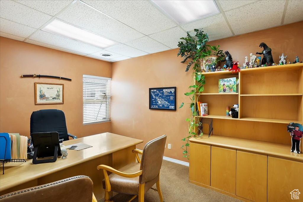 Office space with a drop ceiling, baseboards, light colored carpet, and visible vents