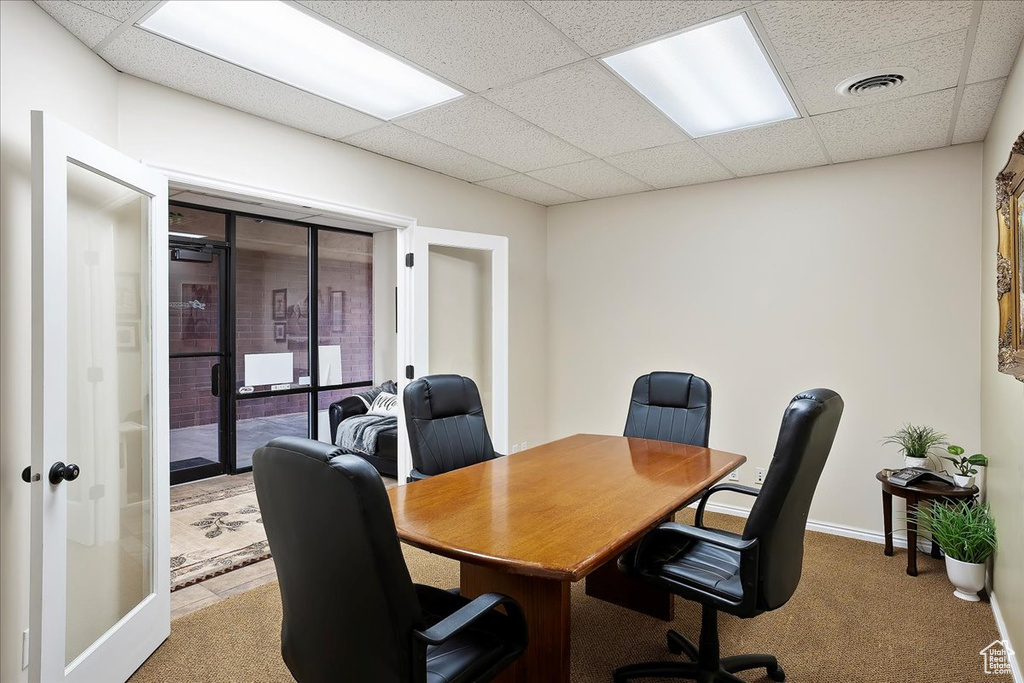 Carpeted home office with a drop ceiling, baseboards, and visible vents