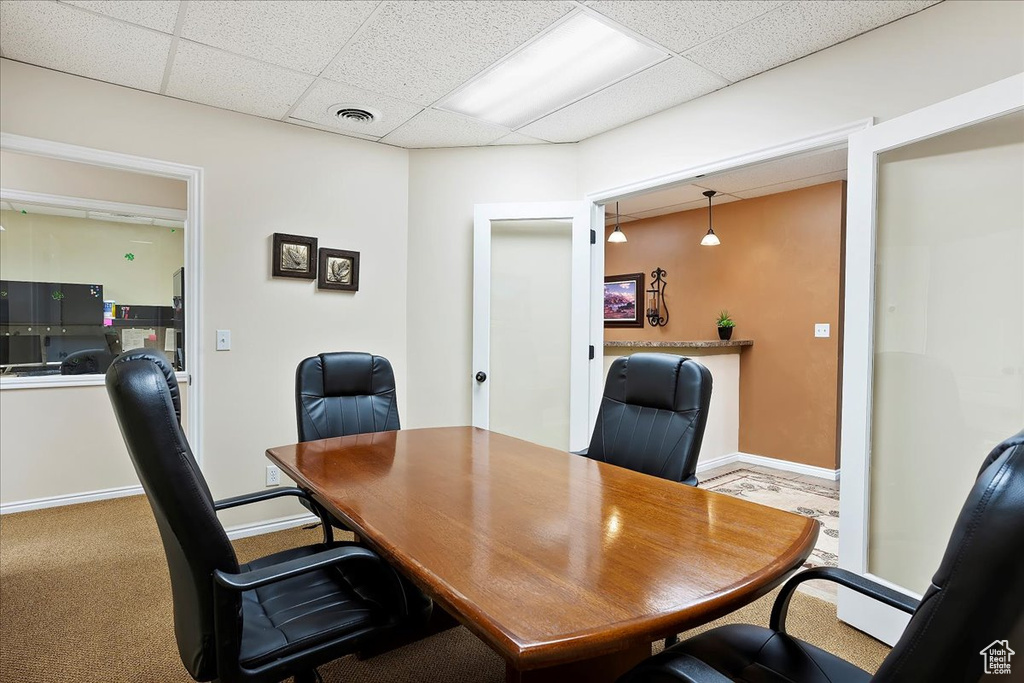 Office area with baseboards, carpet floors, visible vents, and a drop ceiling