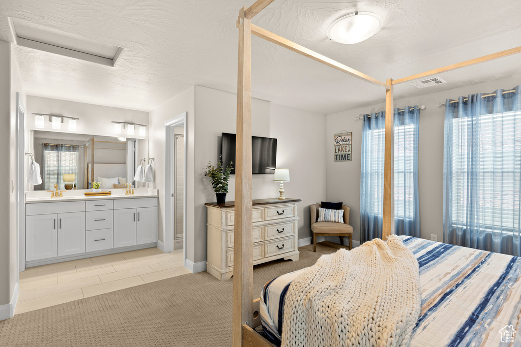 Bedroom featuring baseboards, connected bathroom, and attic access