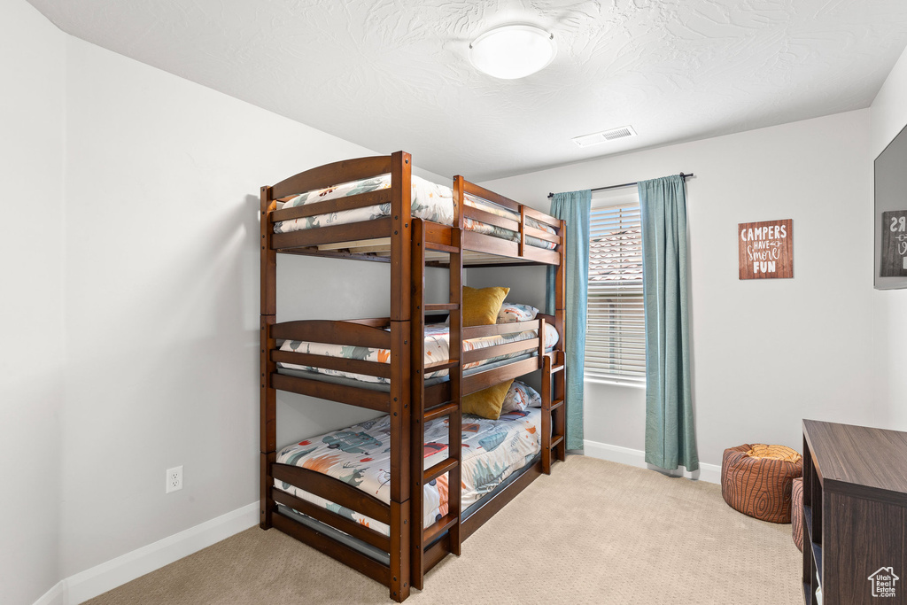 Bedroom with light carpet and baseboards