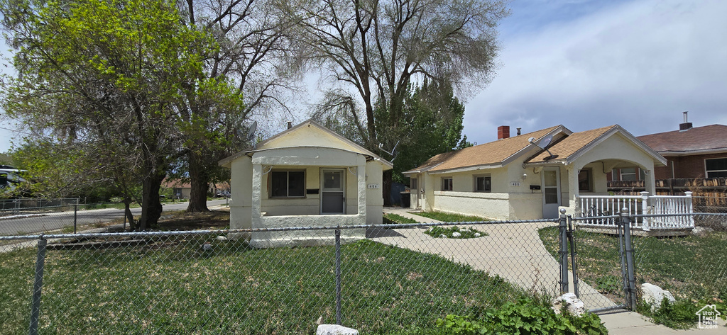 Bungalow with a gate, stucco siding, and a chimney