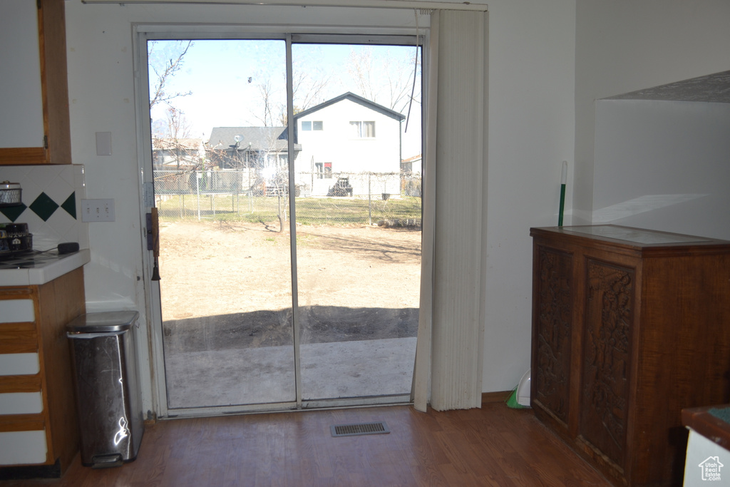 Doorway to outside with wood finished floors and visible vents