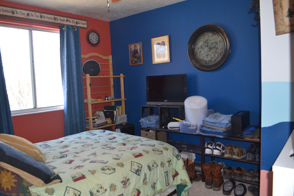 Carpeted bedroom featuring multiple windows and a textured ceiling