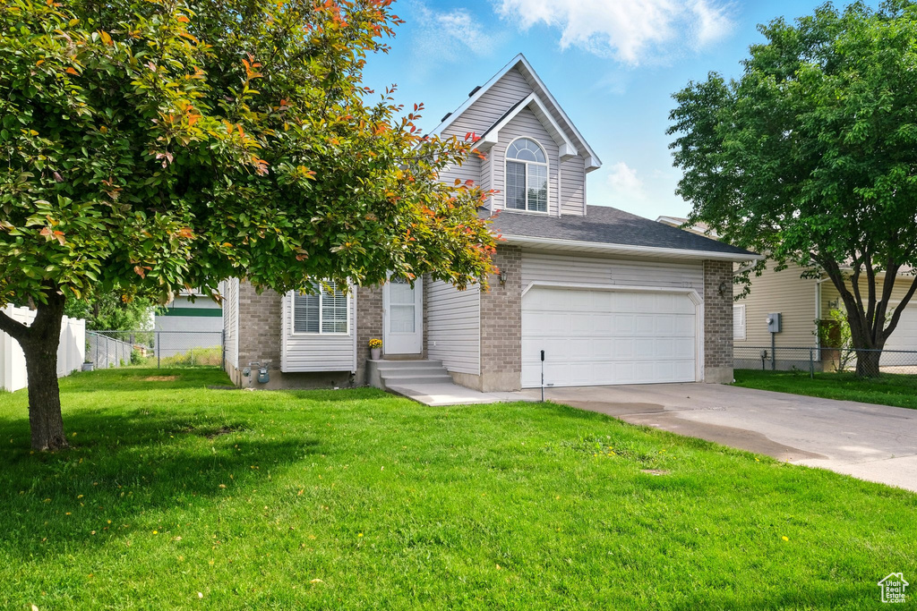 View of front facade with concrete driveway, brick siding, and entry steps