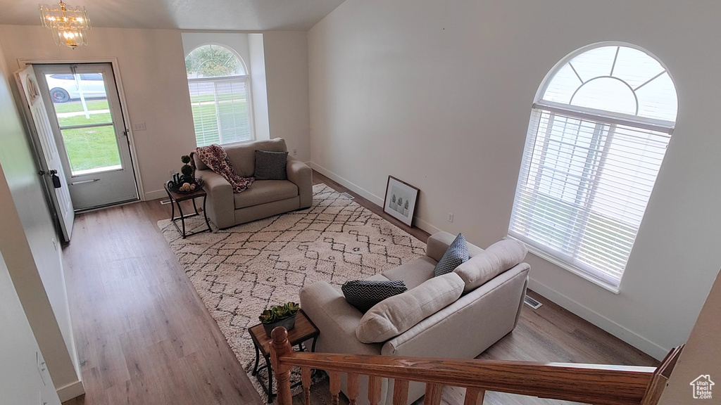 Living room with wood finished floors, baseboards, and a chandelier