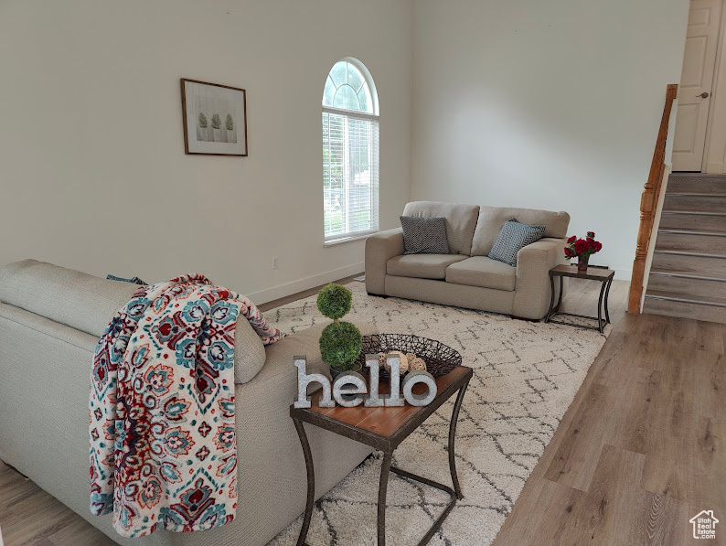 Living room with wood finished floors, stairs, and baseboards