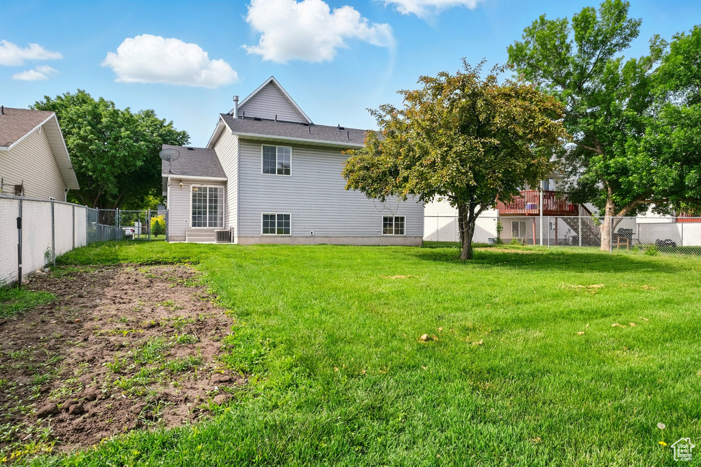 Rear view of house with a shingled roof and central AC