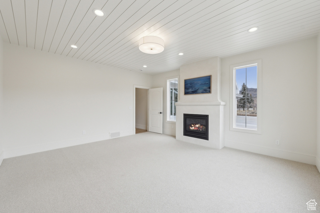 Unfurnished living room with visible vents, a fireplace, recessed lighting, wooden ceiling, and light colored carpet