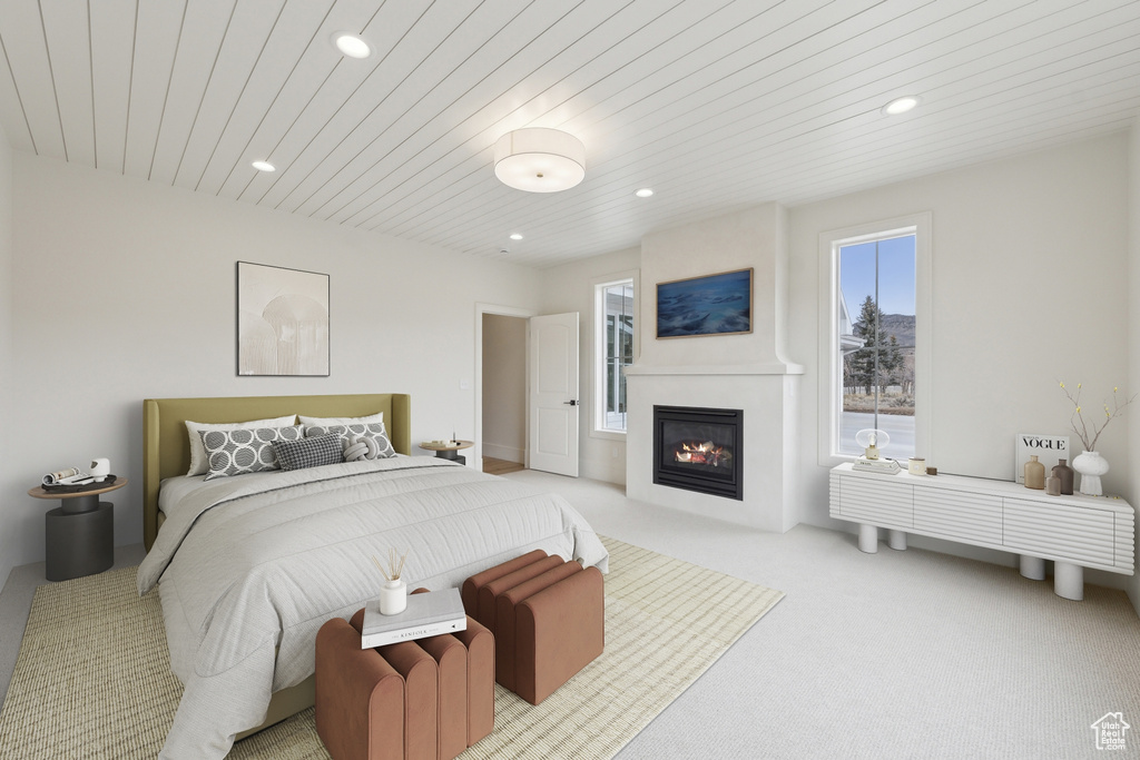 Carpeted bedroom with wooden ceiling, a fireplace, and recessed lighting