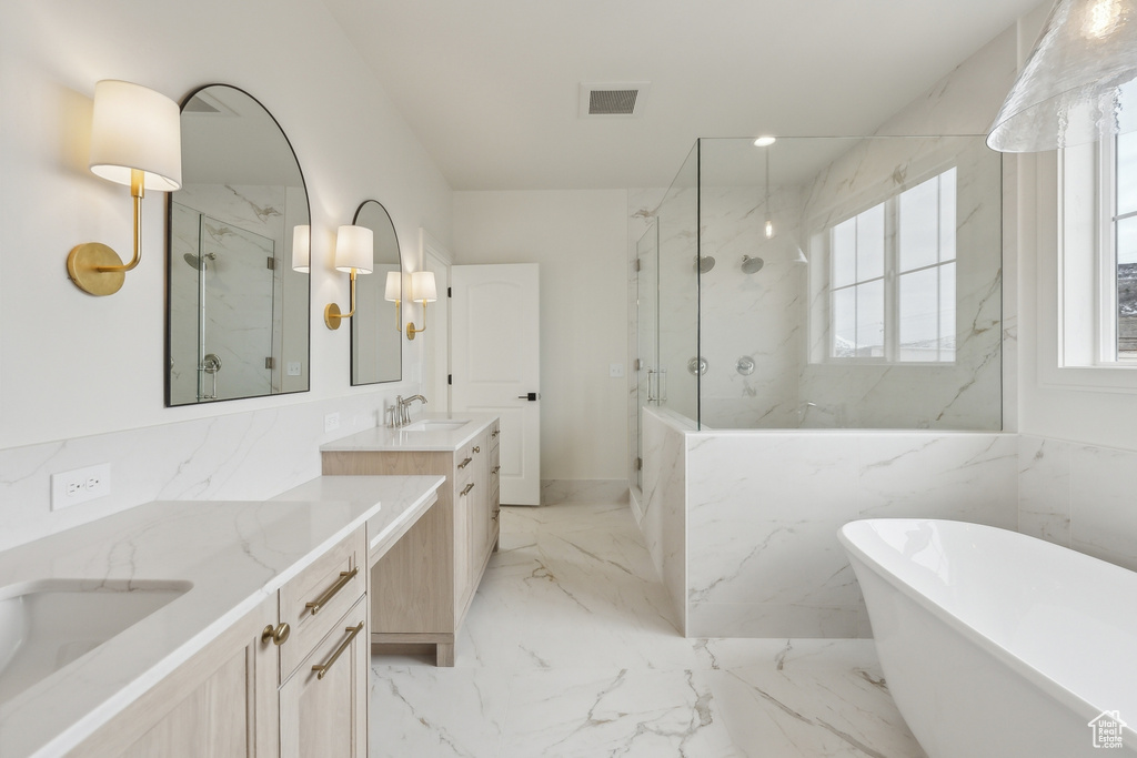 Bathroom with vanity, a marble finish shower, a soaking tub, marble finish floor, and visible vents