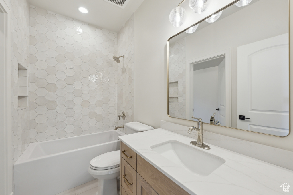 Bathroom featuring toilet, shower / bathing tub combination, and vanity