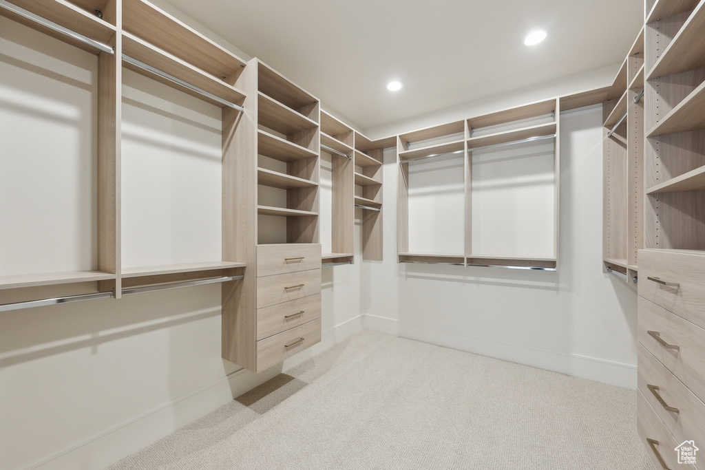 Walk in closet with light colored carpet