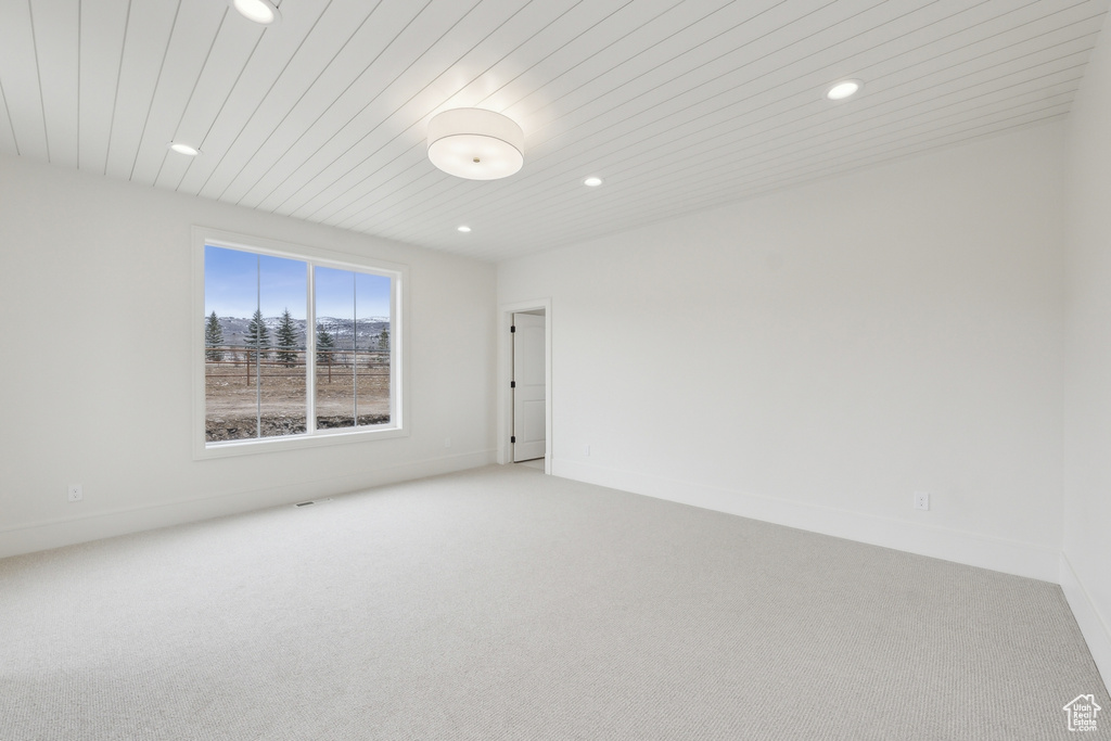 Spare room with baseboards, carpet floors, recessed lighting, and wood ceiling