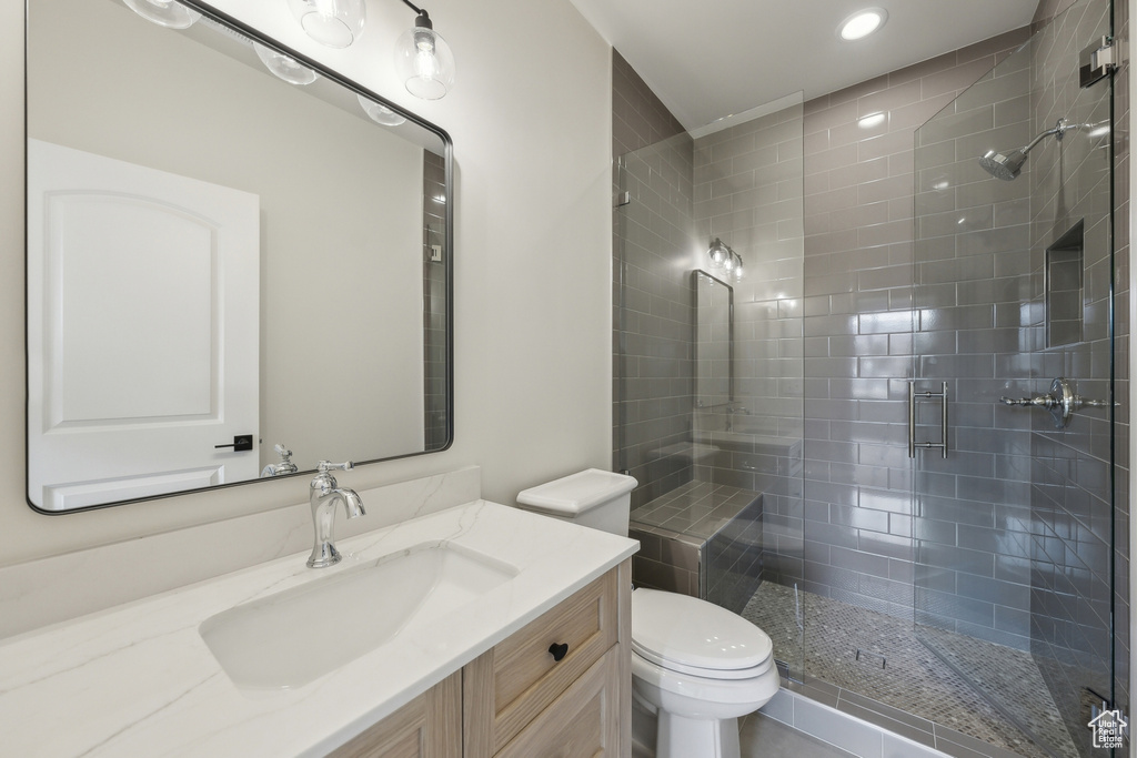 Full bath featuring toilet, a stall shower, and vanity