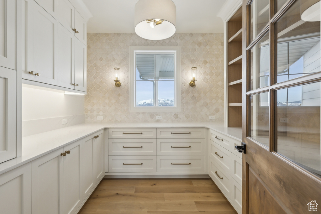 Bathroom with wallpapered walls and wood finished floors