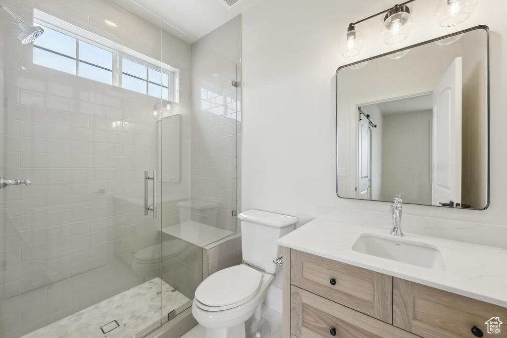 Bathroom with a stall shower, toilet, and vanity