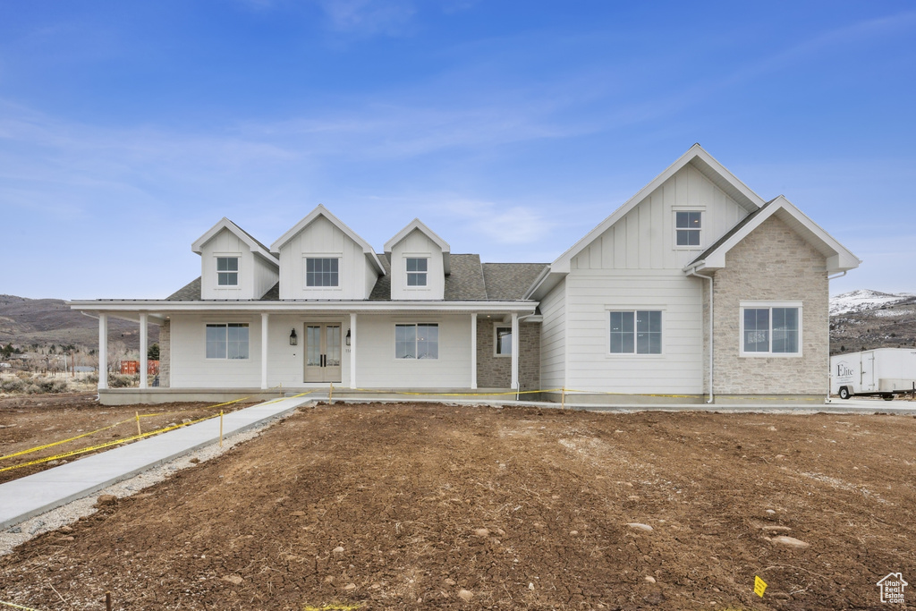 View of front of home featuring a mountain view, a porch, and board and batten siding