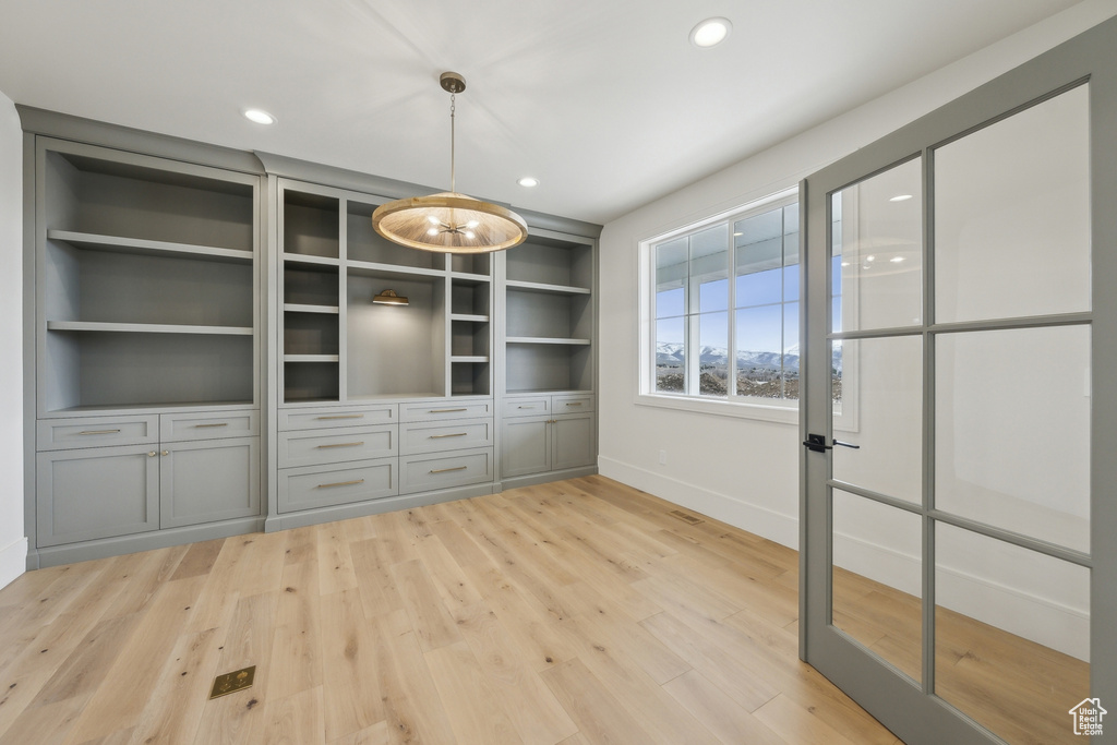 Unfurnished dining area featuring baseboards, recessed lighting, light wood-style floors, and built in features