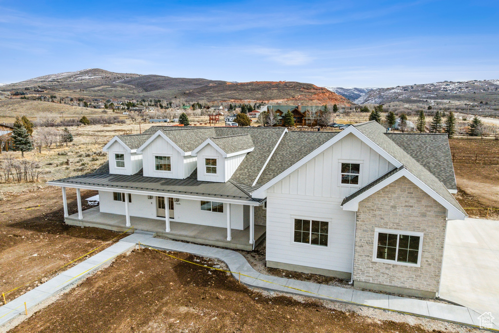 View of front of home featuring a patio, a mountain view, and board and batten siding