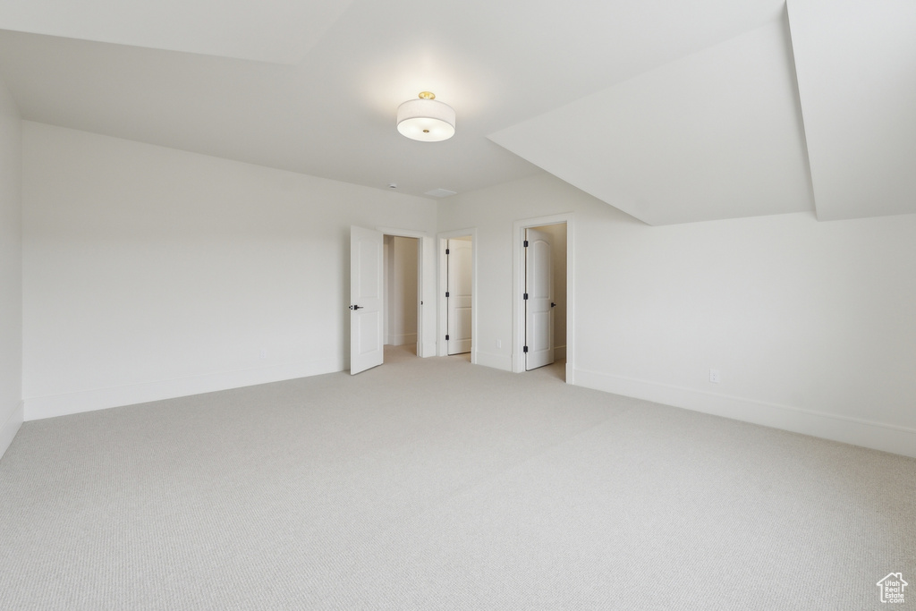 Bonus room featuring baseboards and light carpet