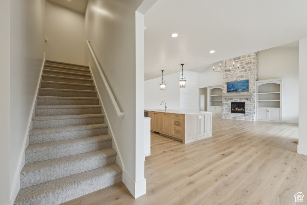 Stairway featuring baseboards, a fireplace, wood finished floors, and recessed lighting
