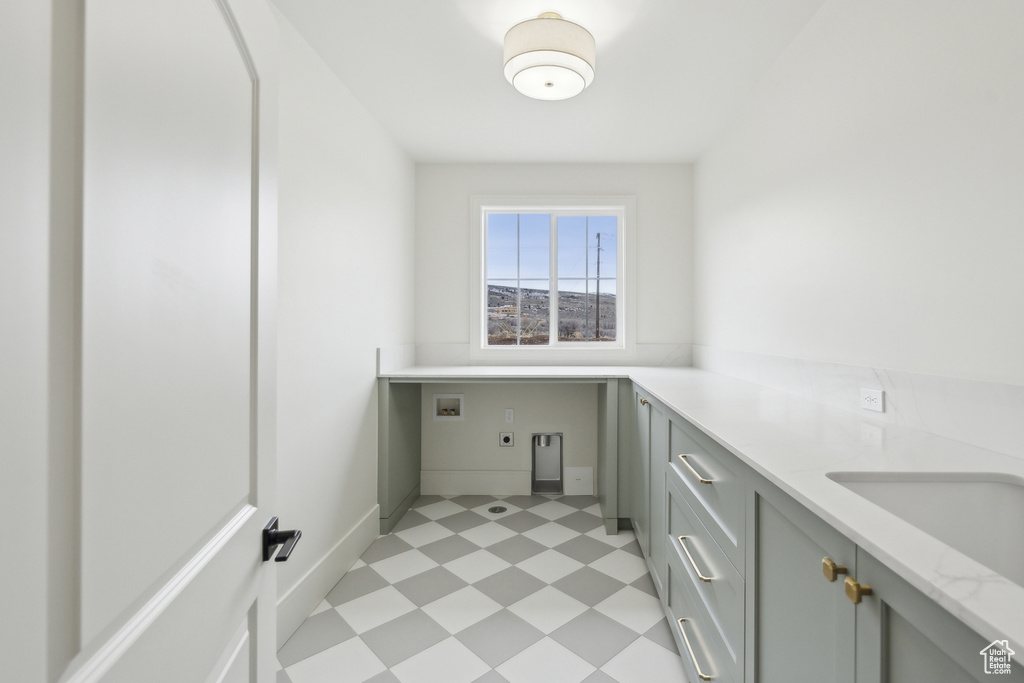 Washroom featuring washer hookup, light floors, hookup for an electric dryer, baseboards, and cabinet space