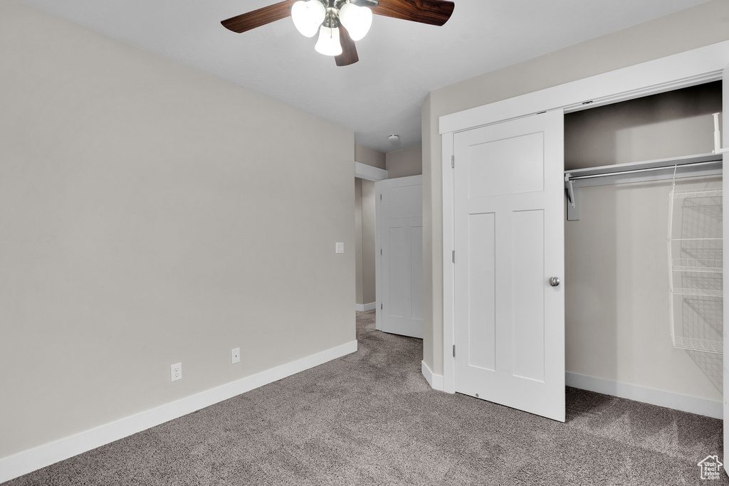Unfurnished bedroom featuring carpet flooring, ceiling fan, and a closet