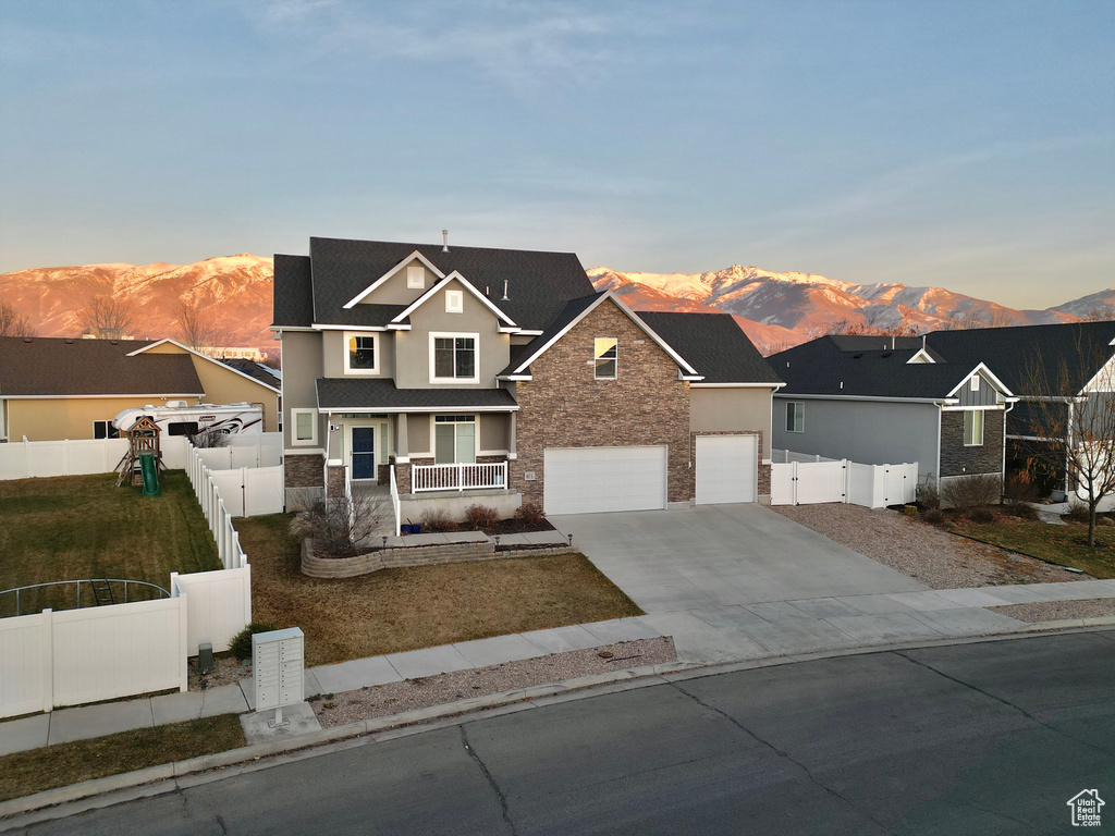 View of front facade featuring covered porch, a mountain view, and a garage