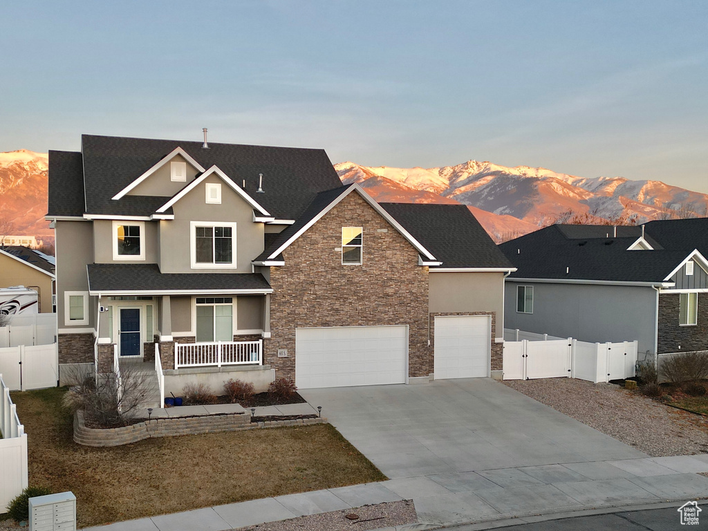 View of front facade featuring covered porch, a mountain view, and a garage