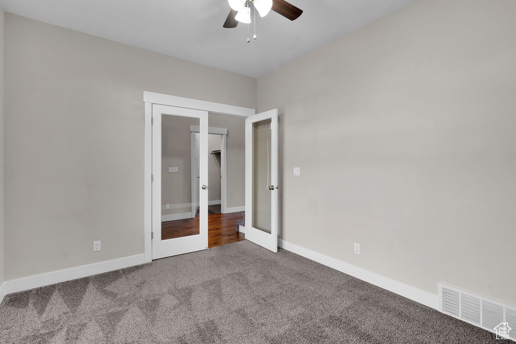 Unfurnished bedroom featuring ceiling fan, a closet, carpet floors, and french doors