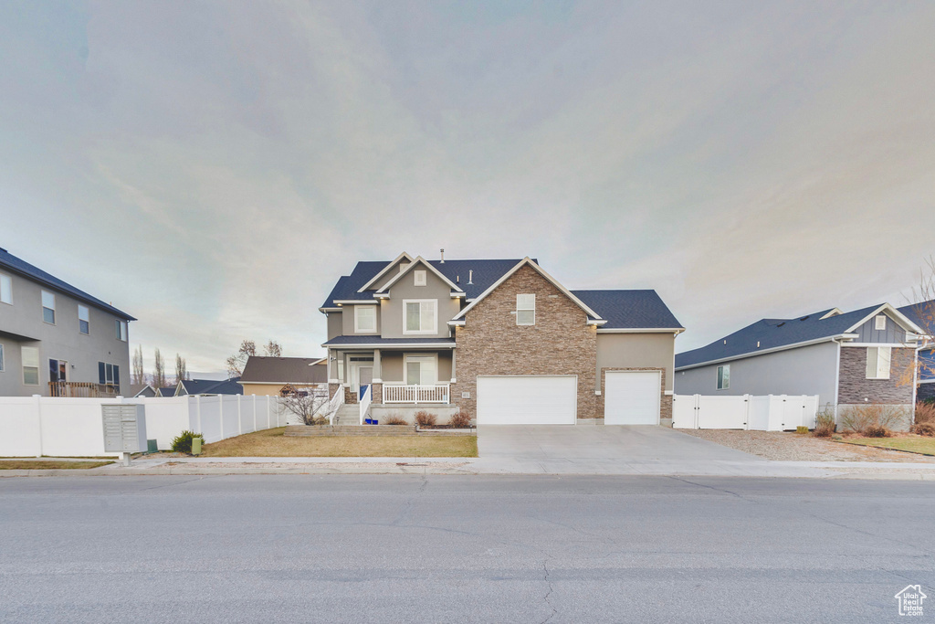 View of front of home with a porch and a garage