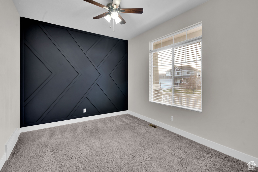 Spare room featuring ceiling fan and carpet