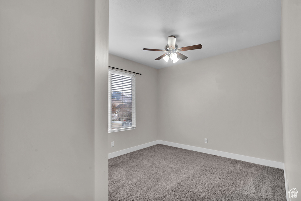 Carpeted spare room with ceiling fan