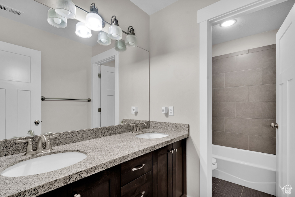 Full bathroom with tile patterned floors, vanity, toilet, and tiled shower / bath